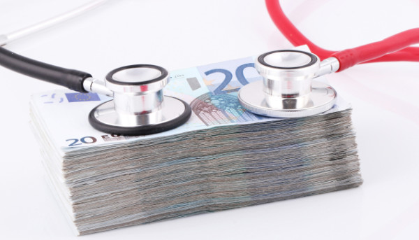 ein Haufen Geld mit einem Stethoskop darauf